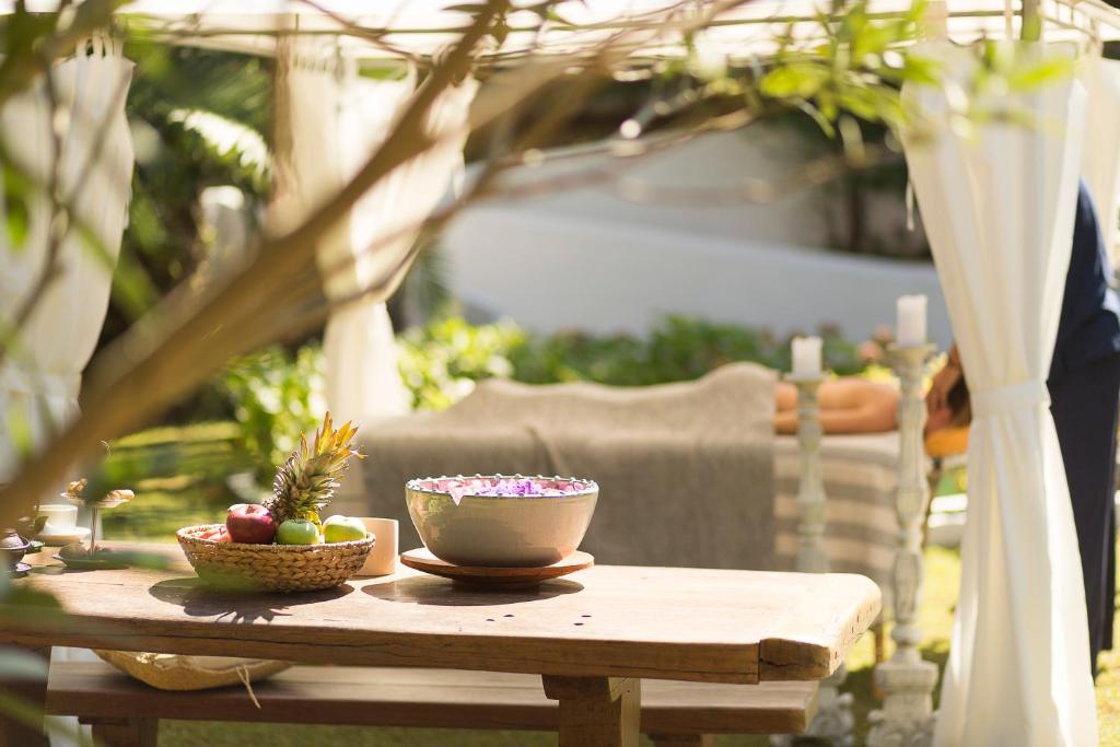 a table with a bowl of apples and a bowl of fruit at Mandraki Village Boutique Hotel in Koukounaries