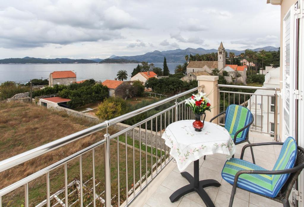 a balcony with a table and chairs and a view of the water at Apartments Ana in Lopud Island