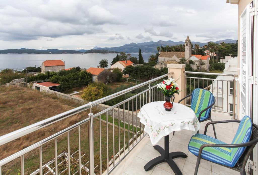 a balcony with a table and chairs and a view of the water at Apartments Ana Lopud in Lopud Island