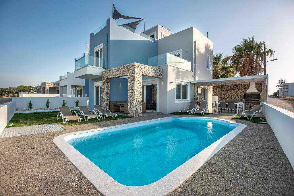 a large white villa with a swimming pool at Tamaris Villa in Mastihari