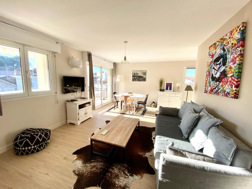 - un salon avec un canapé et une table dans l'établissement Appartement spacieux à Pontaillac, proche plage, à Royan