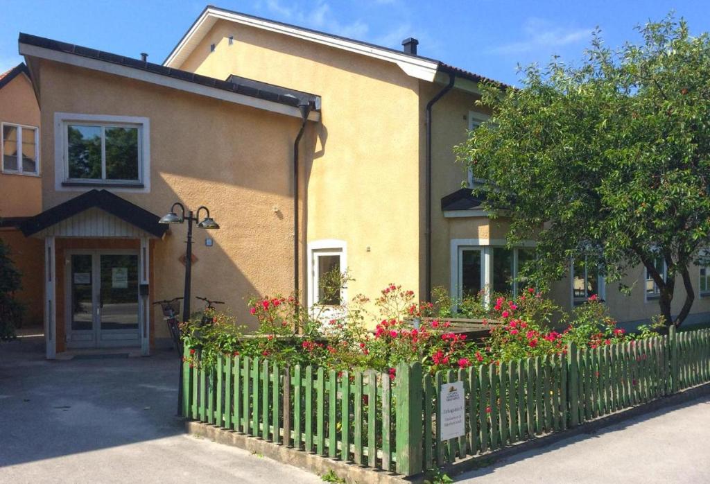 ein Haus mit einem Zaun und Blumen davor in der Unterkunft Birkagatan - Visby Lägenhetshotell in Visby
