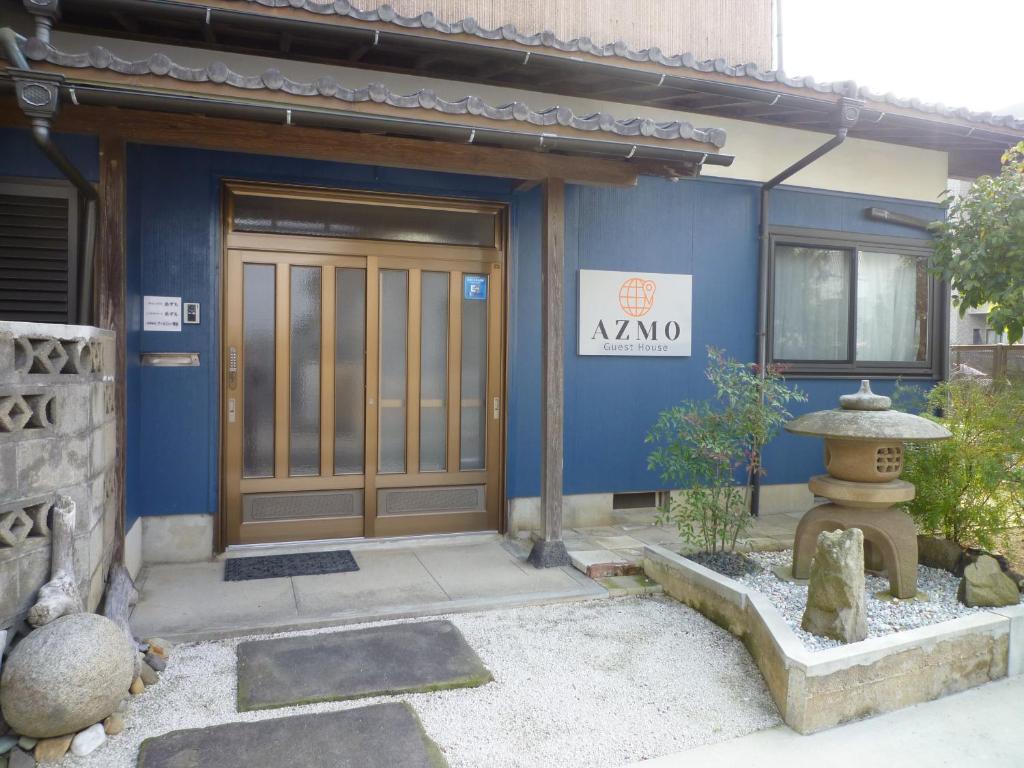 un edificio azul con una puerta delante en ゲストハウス あずも GuestHouse AZMO en Matsue