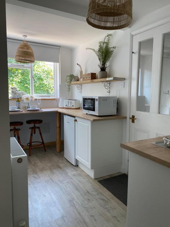 a kitchen with white cabinets and a counter top at Little Limes an Adorable little Suffolk getaway with outside space near Woodbridge in Eyke