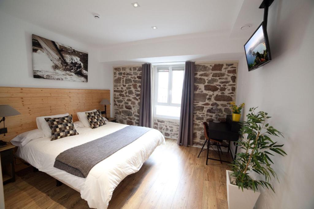 a bedroom with a bed and a tv on the wall at Casa Nicolasa in San Sebastián