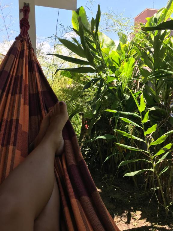 a person is laying in a hammock at Casa no Centrinho para 2 pessoas 100m do Mar in Bombinhas