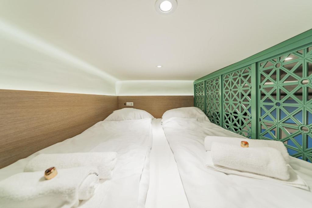 2 camas en una habitación con sábanas blancas y toallas en ZEUS Design Mini Apartment Erlach #10, en Viena