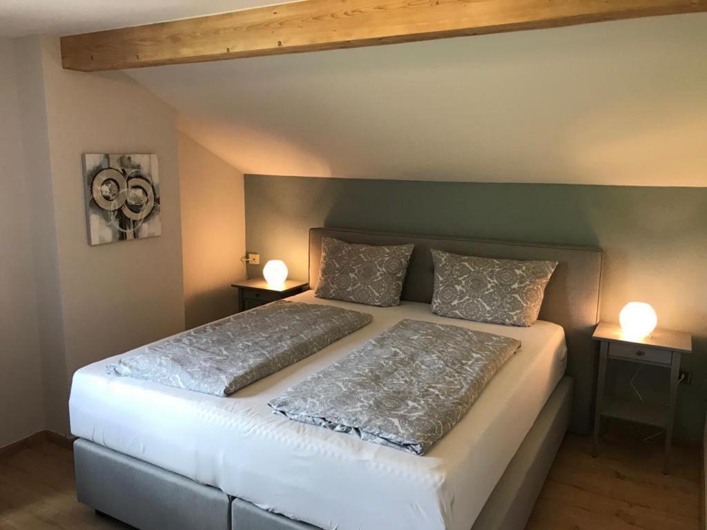 a bedroom with a bed with two lamps on two tables at Wieshof mein Ferienglück in Regen