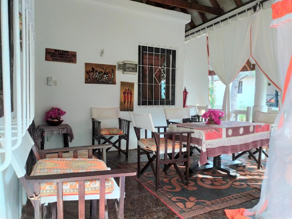 una habitación con mesas y sillas y una habitación con mesa en Villa 36 Karibuni en Malindi