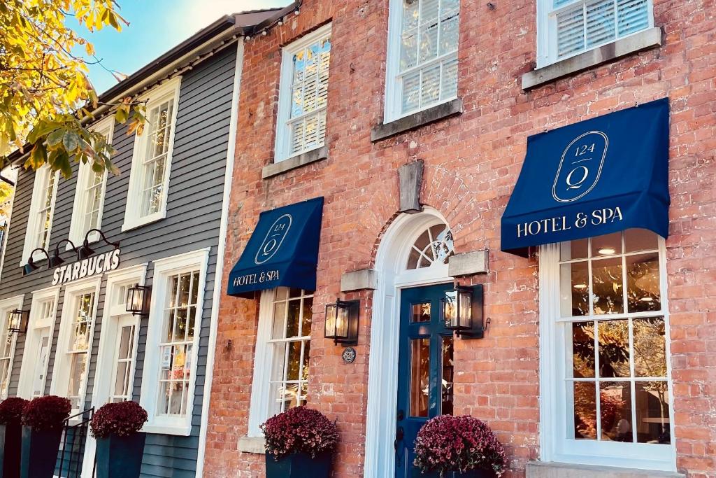 a brick building with blue awnings on it at 124 on Queen Hotel & Spa in Niagara on the Lake