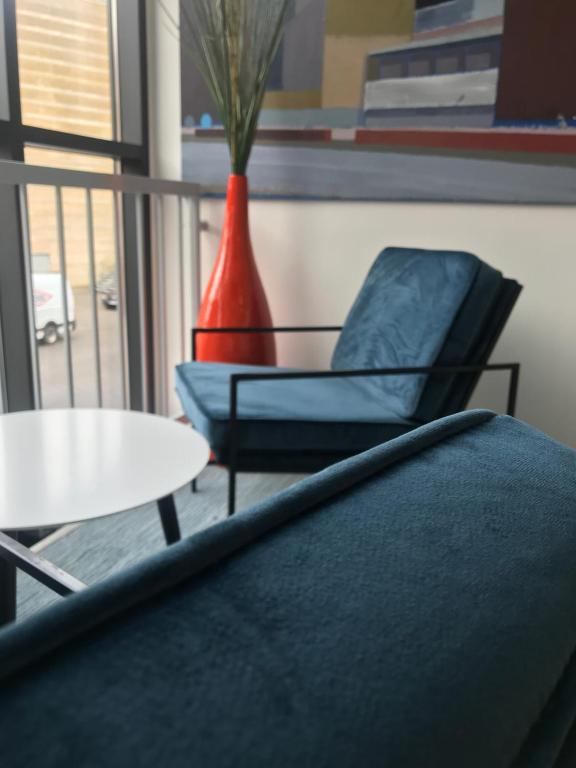 a chair and a table and a vase on a balcony at ApartHotel Faber in Aarhus