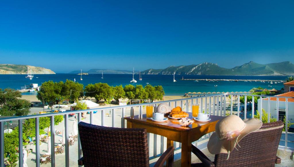 a table on a balcony with a view of the ocean at Hotel Alex in Methoni
