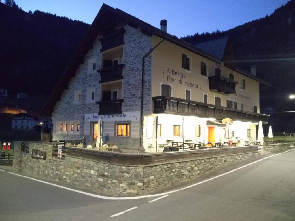 um edifício ao lado de uma rua à noite em Fior di Roccia - Valmalenco - Hotel & Mountain Restaurant em Lanzada