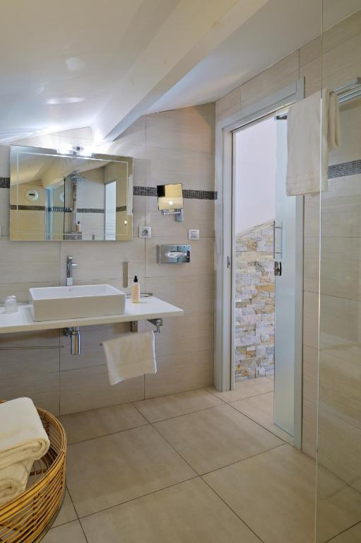 a bathroom with a sink and a mirror and a shower at L&#39;Escale Côté Sud in LʼÎle-Rousse