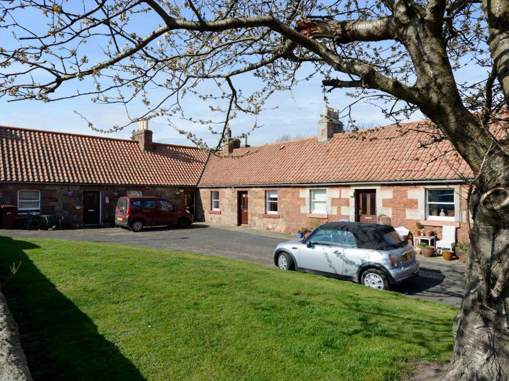 una casa con dos coches aparcados en un estacionamiento en Charming Cottage in North Berwick with Sea Views en North Berwick