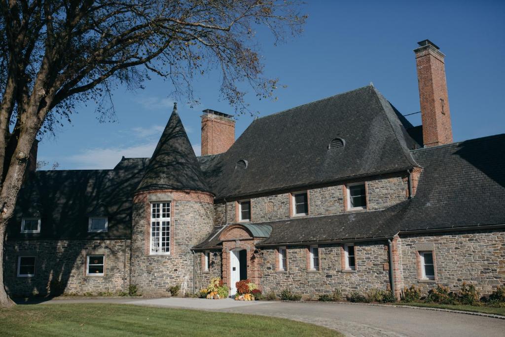 una antigua casa de piedra con techo negro en Shepherd’s Run, en South Kingstown