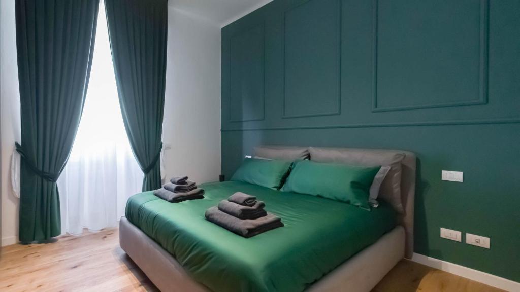 a green bedroom with a bed with towels on it at Cavour 82 in Florence