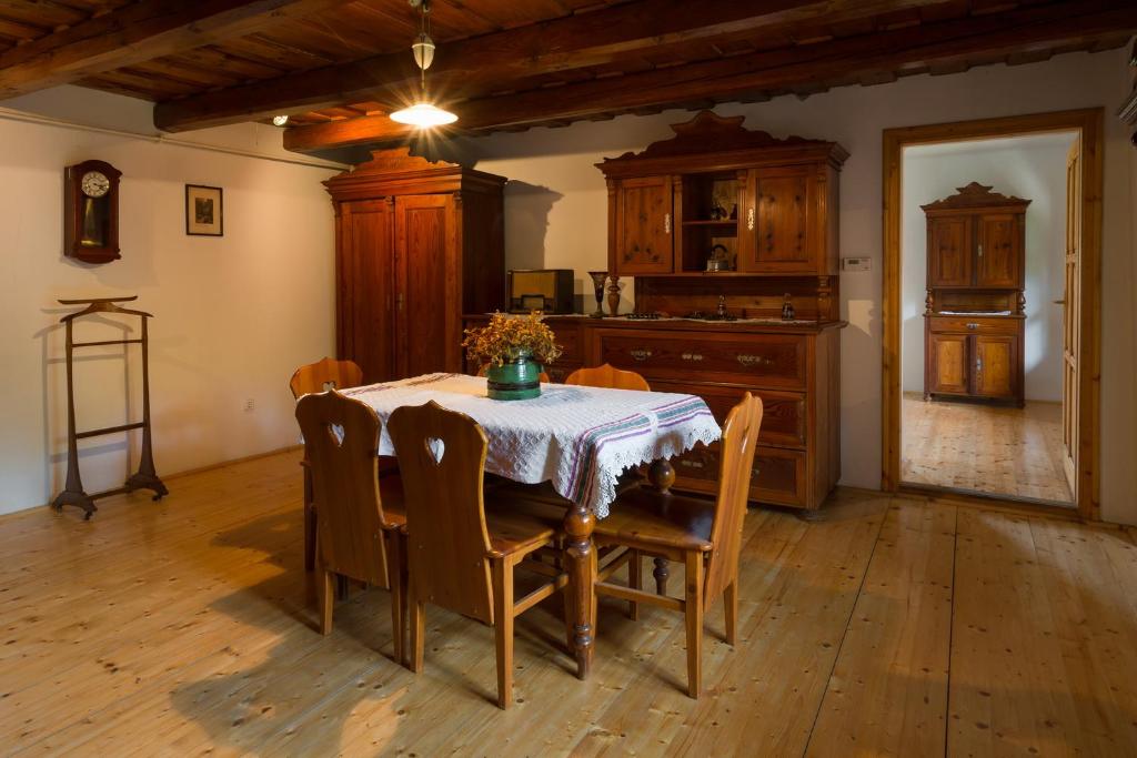 a dining room with a table with chairs and a kitchen at Farmhouse in Köveskál (Balatonfelvidék) for 6 persons in Köveskál