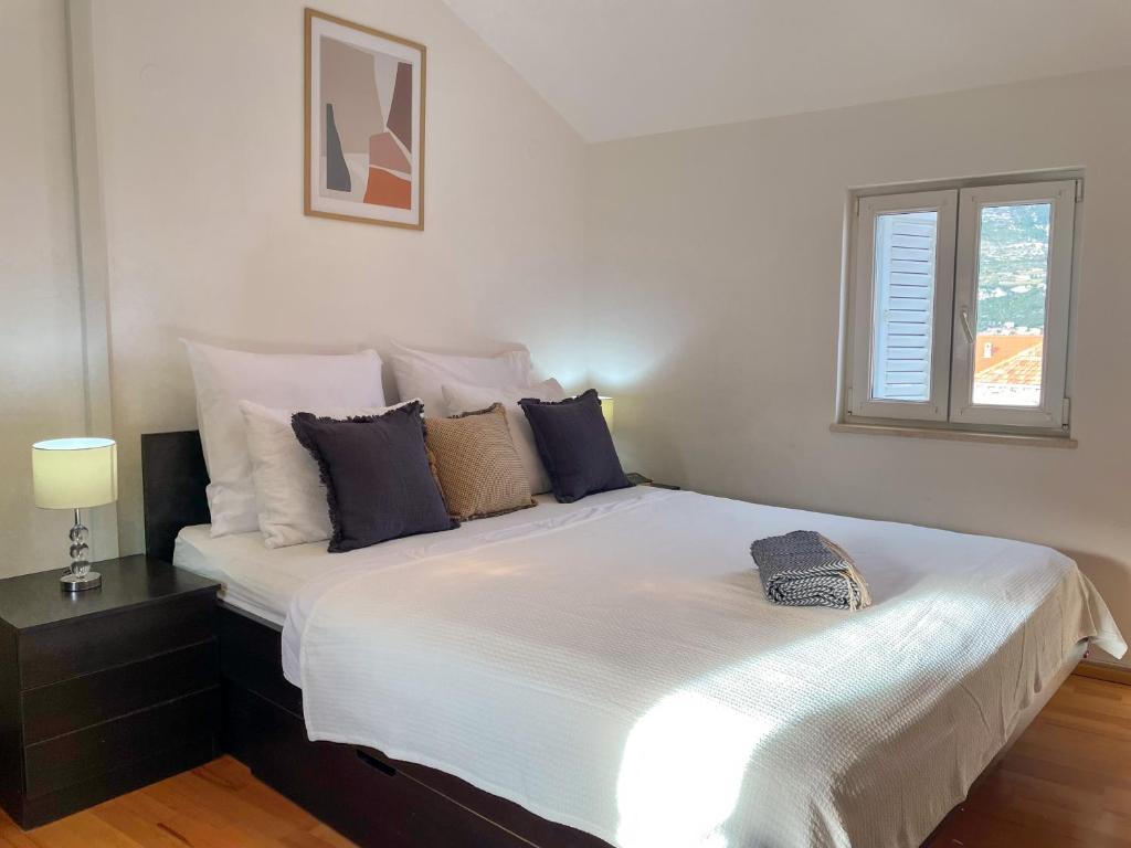 ein Schlafzimmer mit einem großen weißen Bett mit Kissen in der Unterkunft Central Apartment Ira in Korčula