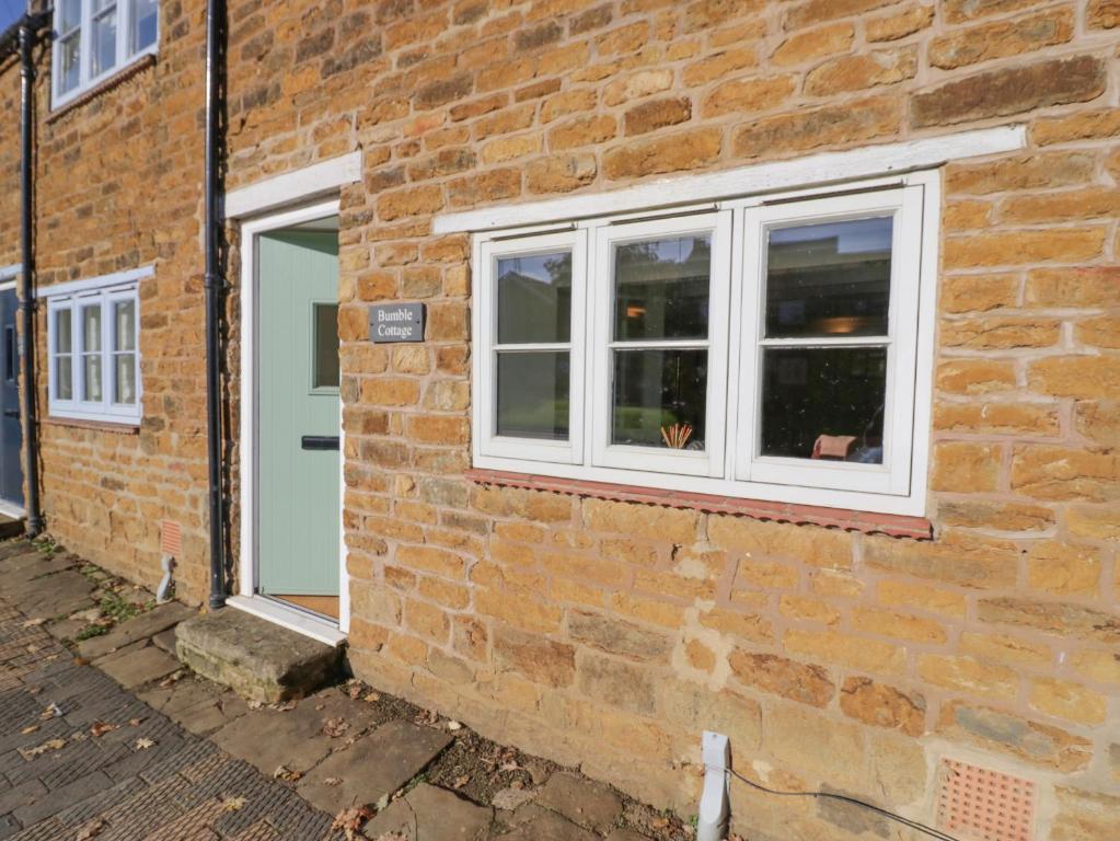 a brick building with a window and a door at Bumble Cottage in Warwick