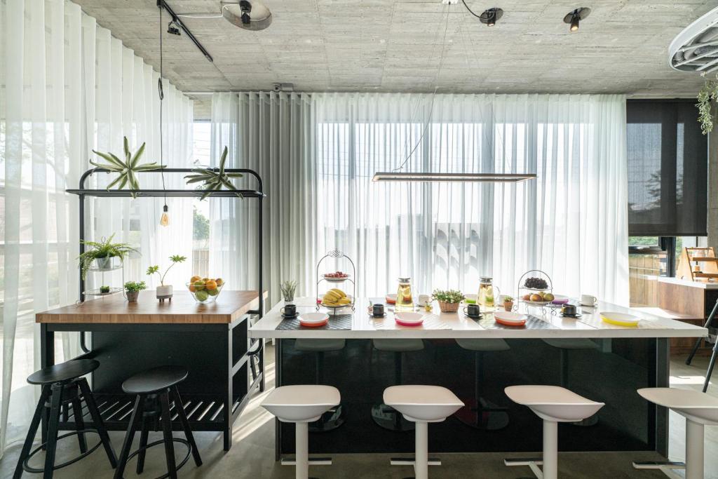 a kitchen with a large island with stools at 蘆薈villa清水模派對k歌BBQ麻將包棟 in Wujie