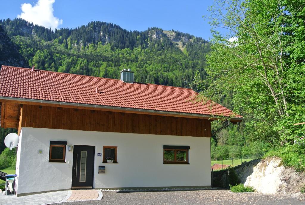 a small white building with a red roof at Ferienhaus Baumberger in Oberammergau