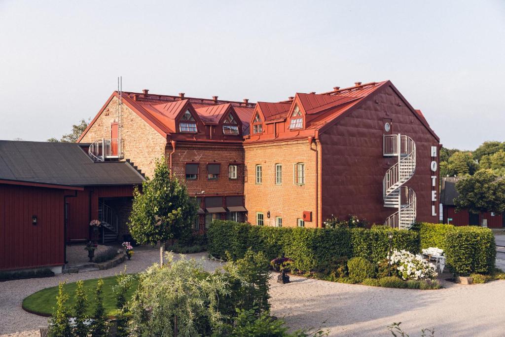 a group of buildings with a large red barn at Hotell Hamngatan 27 in Falkenberg
