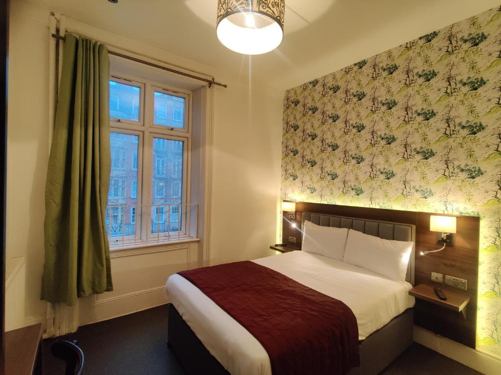 a bedroom with a bed and a window at Chelsea House Hotel - B&B in London