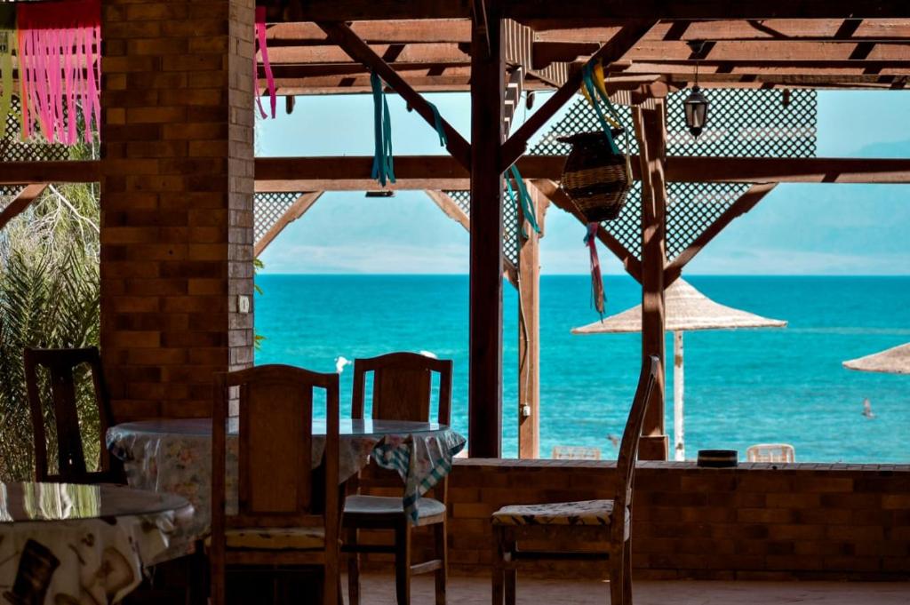 a view of the ocean from a restaurant with a table and chairs at Elbadawy camp in Nuweiba