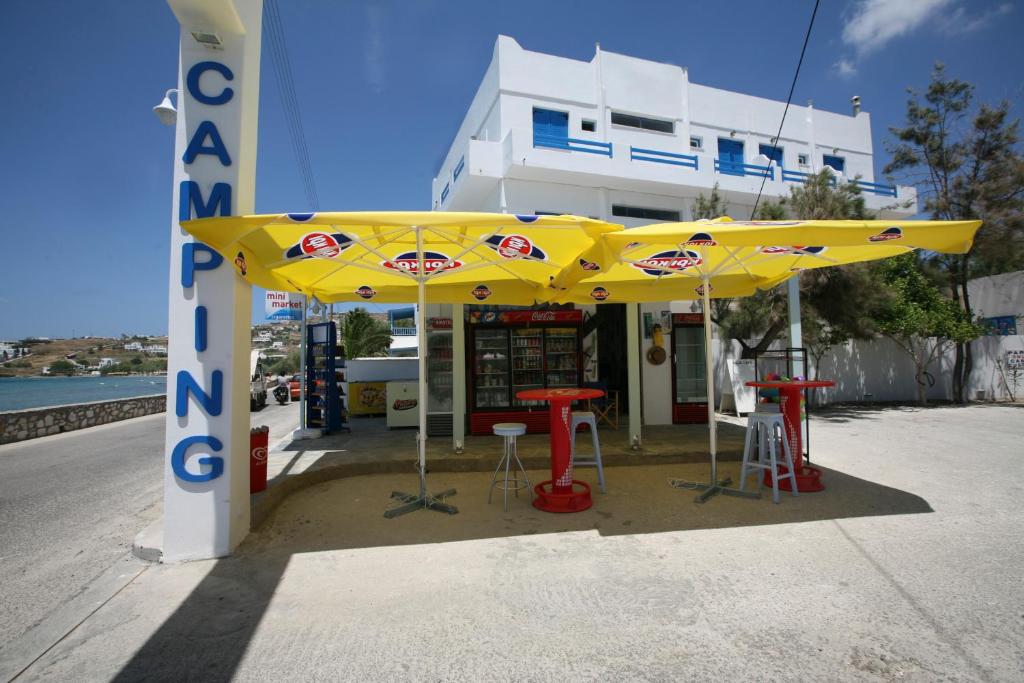 a yellow umbrella in front of a gas station at Camping Koula in Parikia