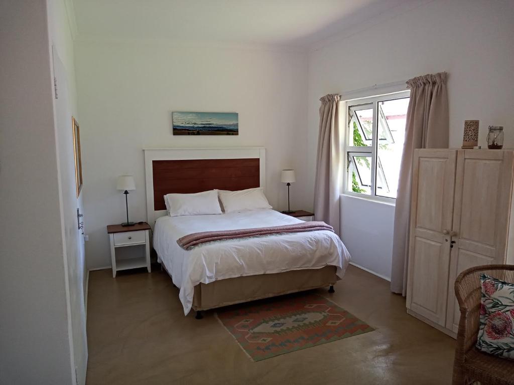 a bedroom with a large bed and a window at Sani's Rest in Himeville