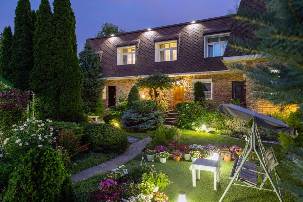 uma casa com um jardim à noite com um relvado sidx sidx em Апартаменты в гостевом домике em Almaty