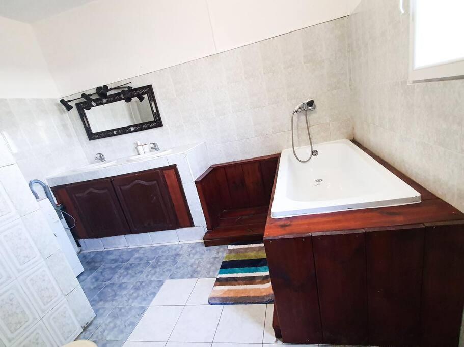 a bathroom with a sink and a tub and a mirror at l'auberge de l'île :la villa in Dzaoudzi