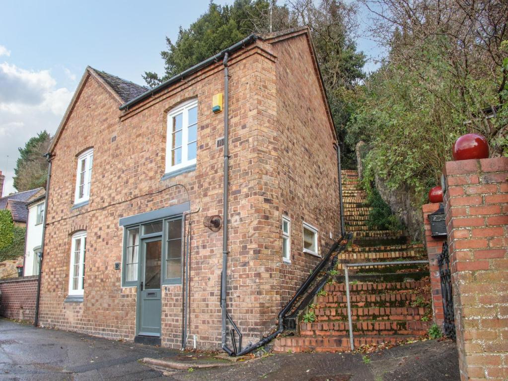 ein Backsteinhaus mit einer seitlichen Treppe in der Unterkunft 32 Church Hill in Telford