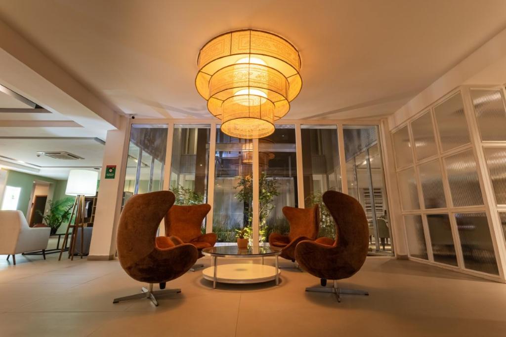 a lobby with chairs and a table and a chandelier at Ecco Hotel Fortaleza in Fortaleza