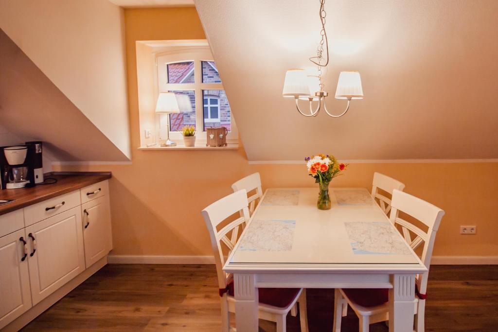 a dining room with a white table and chairs at Int Hörn 3 OG in Krummhörn