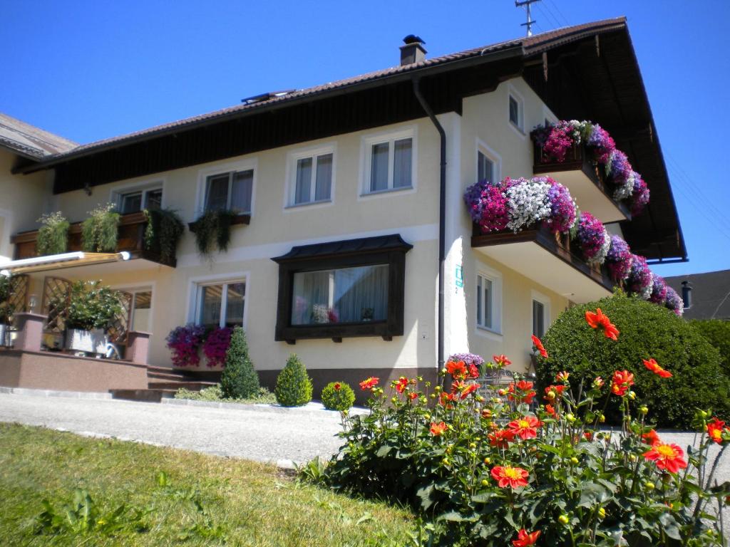ein Haus mit Blumen davor in der Unterkunft Gästehaus Jedinger in Sankt Georgen im Attergau