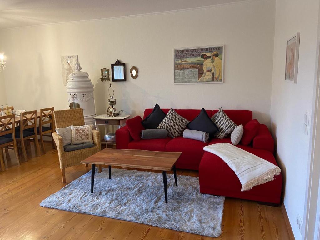 Alkersum的住宿－An der Marsch，客厅配有红色的沙发和桌子