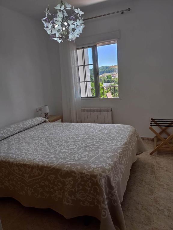 1 dormitorio con cama y lámpara de araña en Apartamento La Relojera 1 en Jarandilla de la Vera