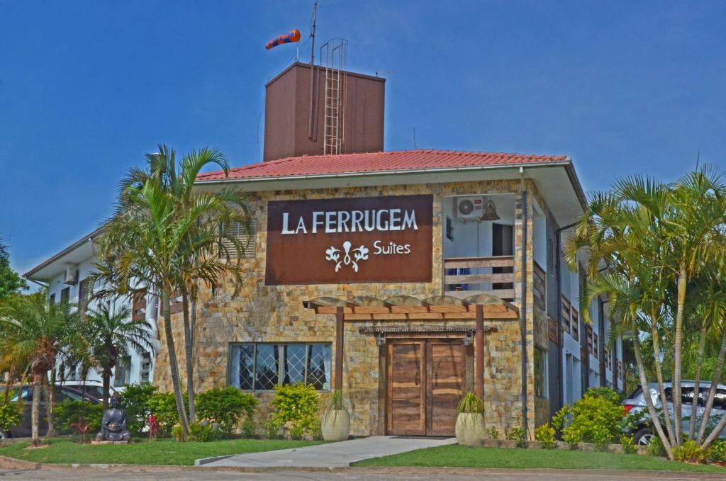 ein Gebäude mit einem Schild auf der Vorderseite in der Unterkunft La Ferrugem Suites - 100 mts da Praia in Garopaba