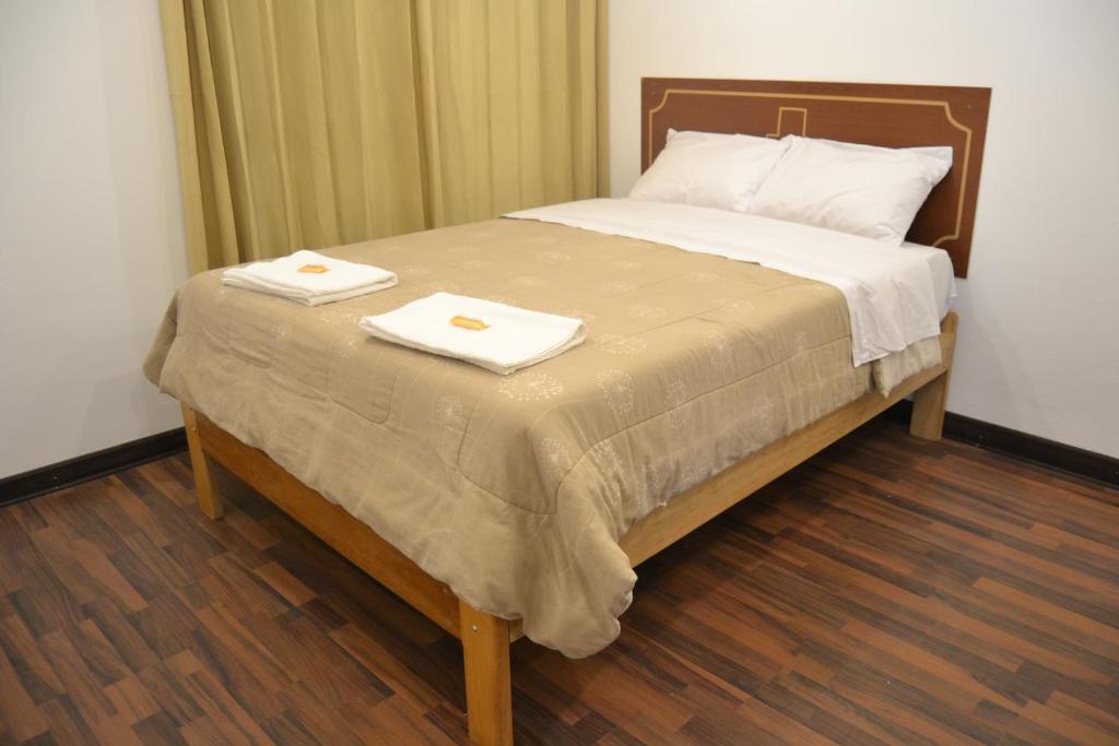 Una cama con dos toallas encima. en Apu Wasi en Cuzco