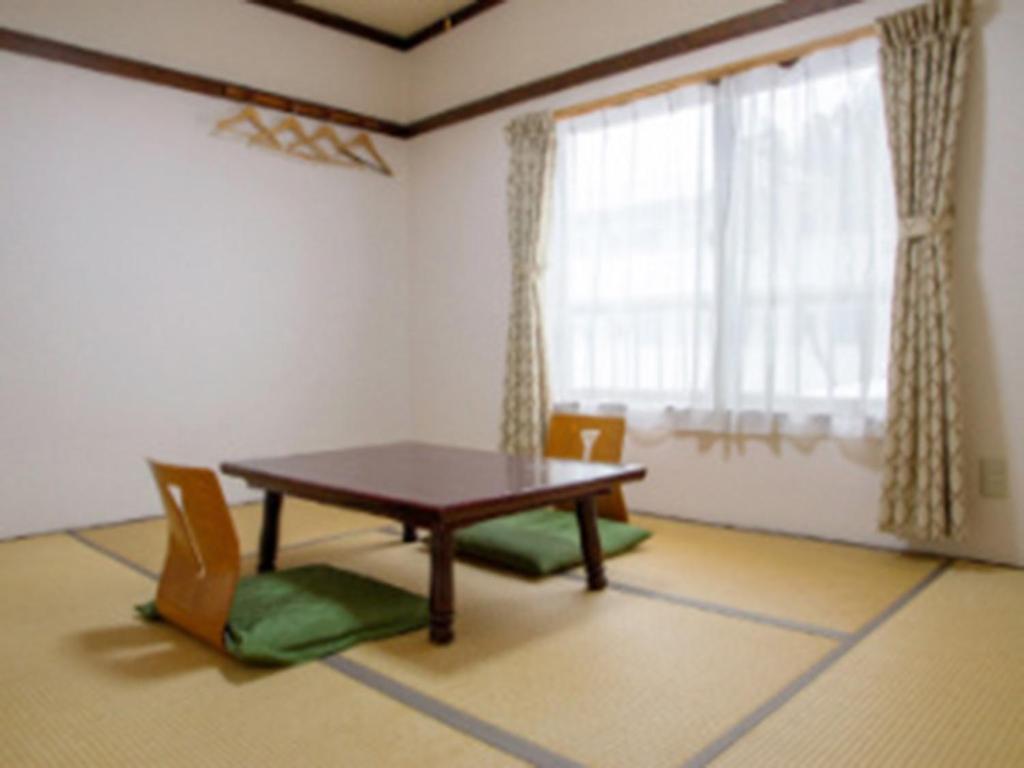 comedor con mesa, sillas y ventana en Ryokan Seifuso - Vacation STAY 02206v en Matsumoto