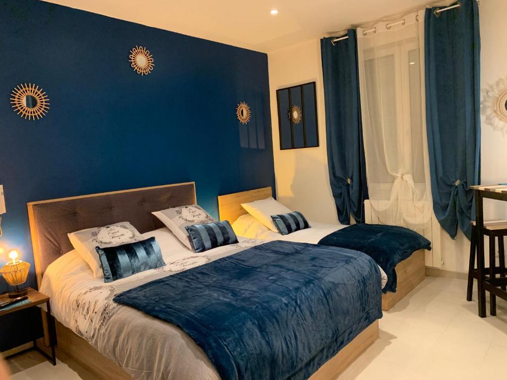 1 dormitorio con 2 camas y paredes azules en La Liberté, en Narbona