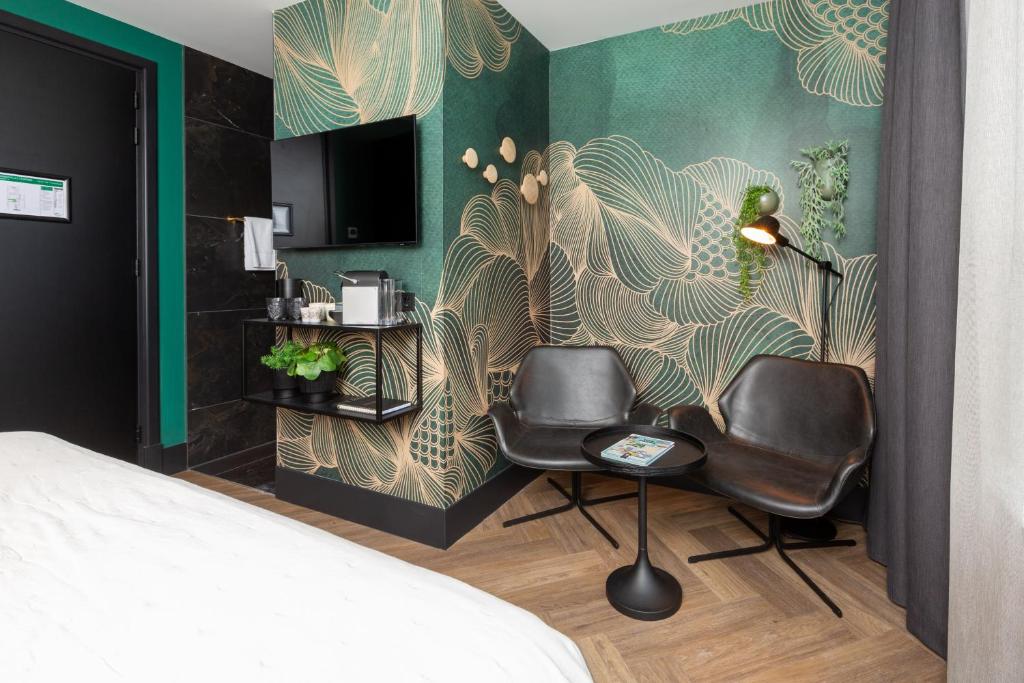 een slaapkamer met 2 stoelen en een muurschildering bij Boutiquehotel Princenjagt in Middelburg