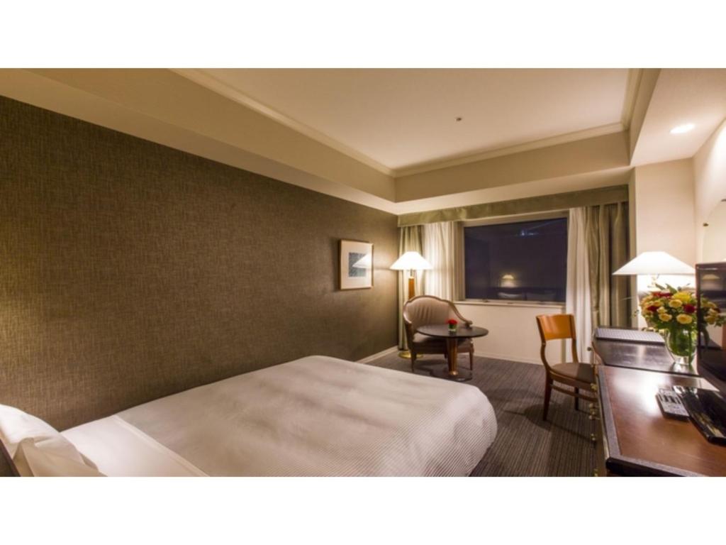 una camera d'albergo con letto e scrivania di The QUBE Hotel Chiba - Vacation STAY 02227v a Chiba