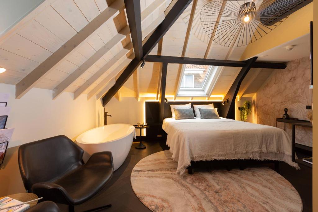 - une chambre avec un lit et une chaise dans l'établissement Boutiquehotel Princenjagt, à Middelbourg