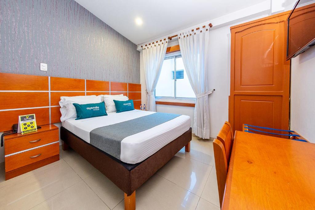 Un dormitorio con una cama grande y una ventana en Ayenda Optimum, en Pereira