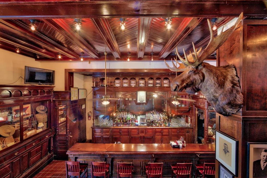 a room with a bar with a deer head on the wall at Menger Hotel in San Antonio
