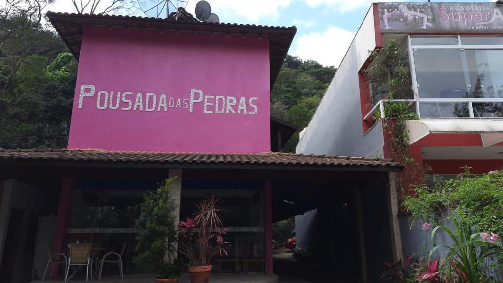 una señal rosa en el lateral de un edificio en Pousada das Pedras en Toque Toque Pequeno