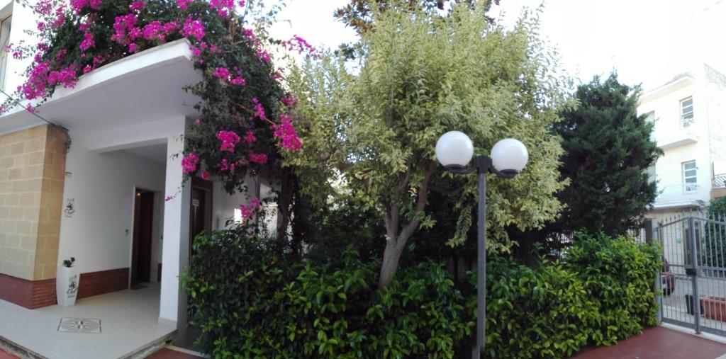 a street light next to a building with pink flowers at B & B La Magnolia in Specchiolla